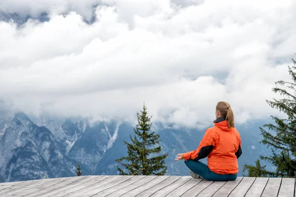 Junge Frau meditiert auf dem Gipfel des Berges — Stockfoto