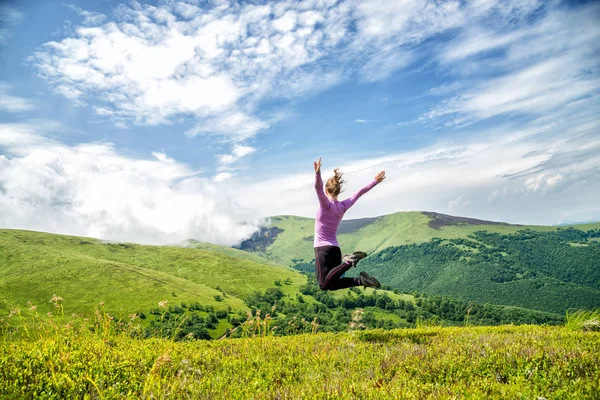 Jeune femme sautant dans les montagnes — Photo