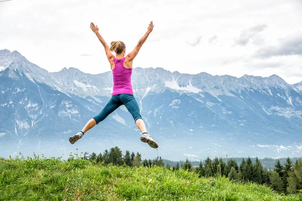 Jonge vrouw op de top van de berg — Stockfoto