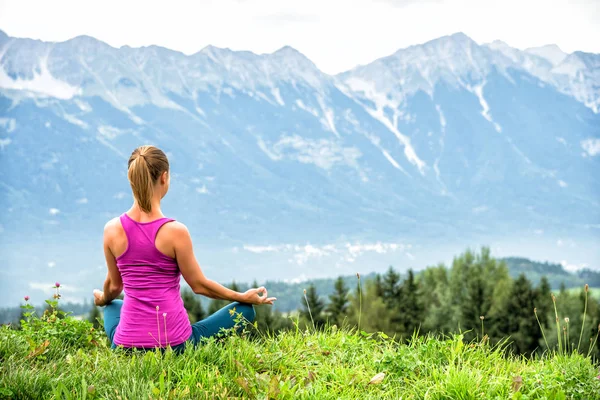 Ung kvinna meditera på toppen av berget — Stockfoto