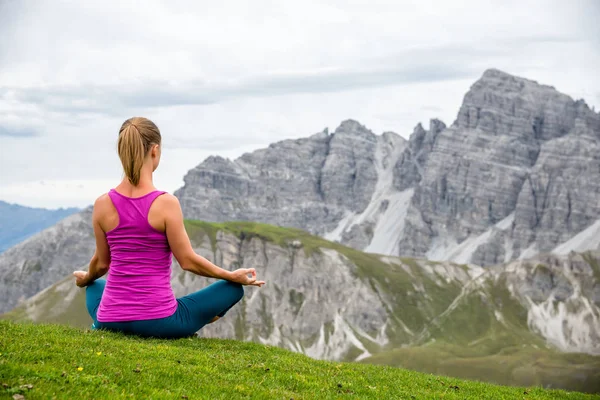 Ung kvinna meditera på toppen av berget — Stockfoto