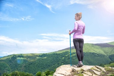 Dağlarda yürüyüş yapan genç bir kadın.