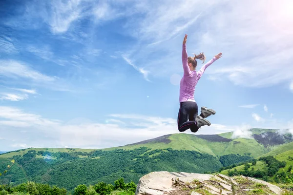 Mujer joven saltando en las montañas — Foto de Stock