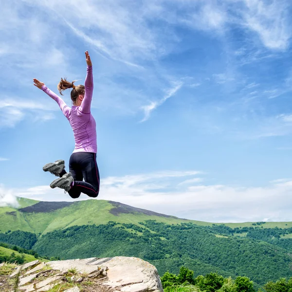 Mujer joven saltando en las montañas — Foto de Stock