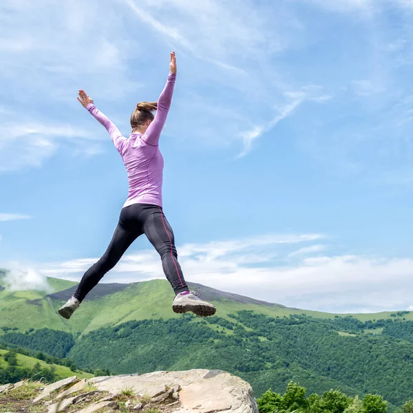 Jonge vrouw springen in de bergen — Stockfoto