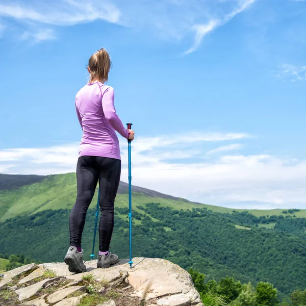 Dağlarda yürüyüş yapan genç bir kadın.