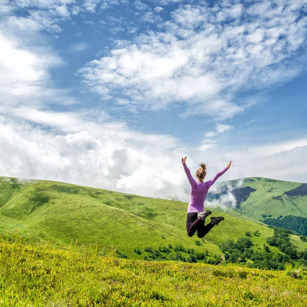 Mujer joven saltando en las montañas — Foto de Stock