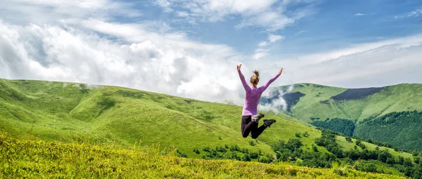 Junge Frau springt in die Berge — Stockfoto