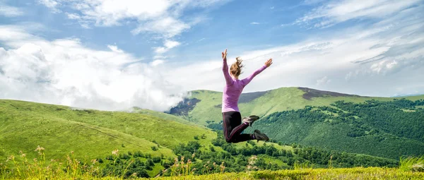 Young woman jumping in the mountains — Stock Photo, Image