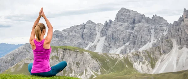 Junge Frau meditiert auf dem Gipfel des Berges — Stockfoto