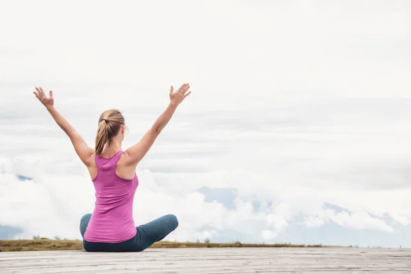 Joven mujer meditar en la cima de la montaña — Foto de Stock