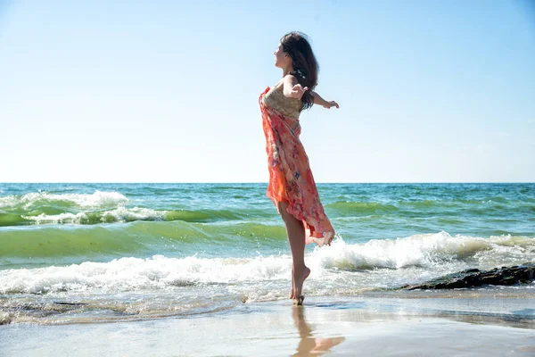 Mujer joven saltando en la playa — Foto de Stock