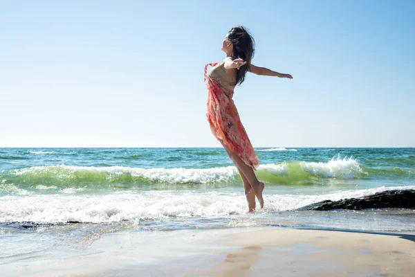 Giovane donna che salta sulla spiaggia — Foto Stock