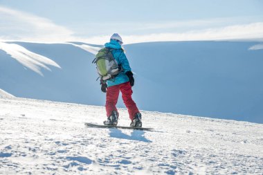Genç kadın snowboard üzerinde
