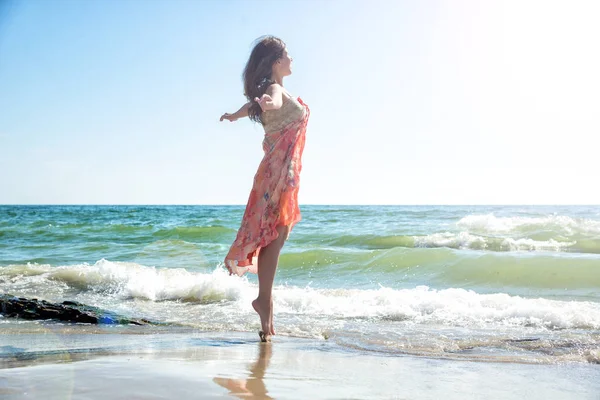 Mujer joven saltando en la playa — Foto de Stock