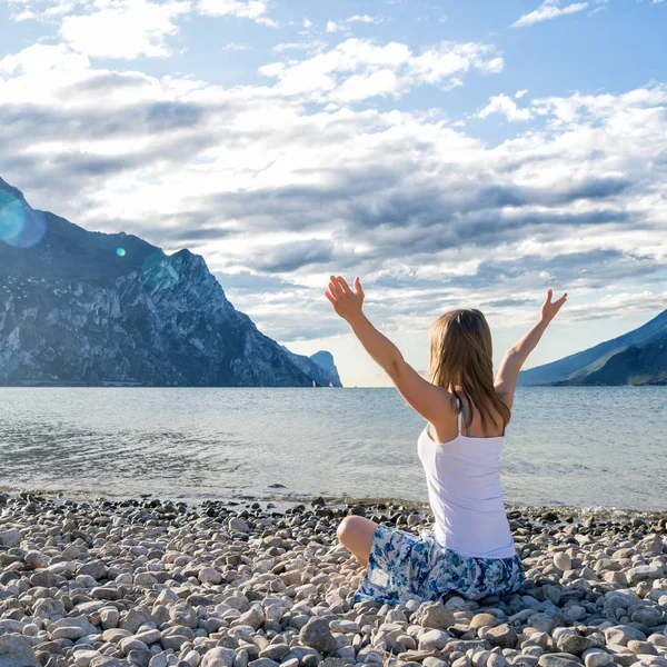 Kvinna som mediterar på sjön — Stockfoto