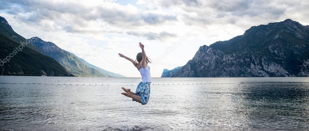 Woman jumping at the lake