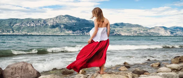 Menina bonita em vestido vermelho pelo mar . — Fotografia de Stock