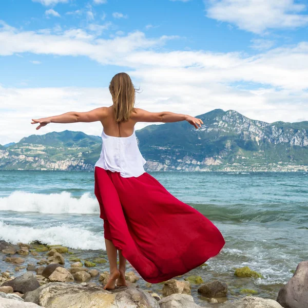 Vacker flicka i röd klänning vid havet. — Stockfoto