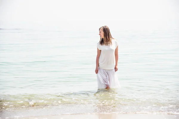 Vrouw die aan het strand staat — Stockfoto