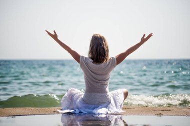 Denizde meditasyon yapan bir kadın