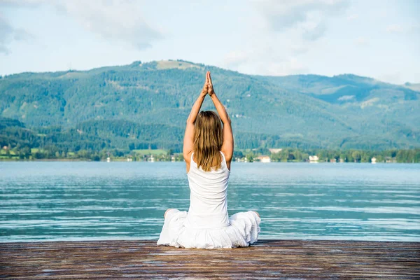 Frau meditiert am See — Stockfoto