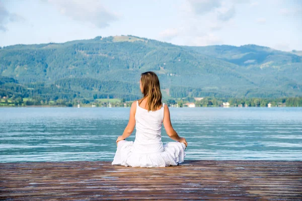 Femme méditant au lac — Photo