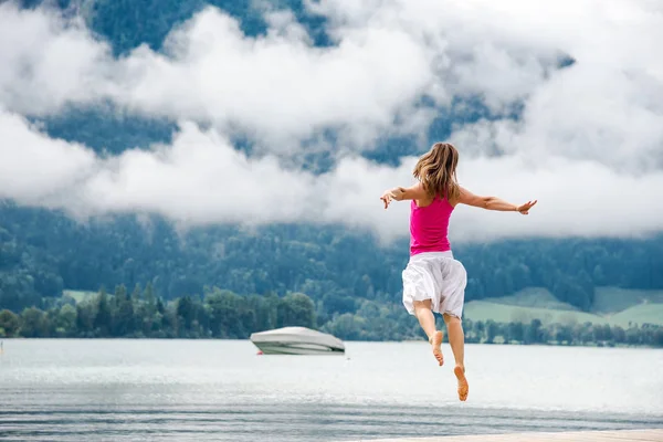 Mujer saltando en el lago — Foto de Stock