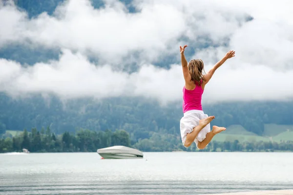 Mujer saltando en el lago — Foto de Stock