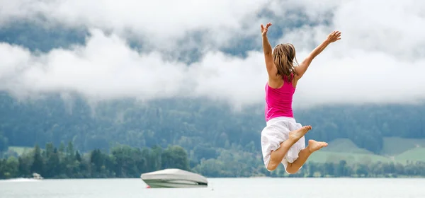 Vrouw springen op het meer — Stockfoto