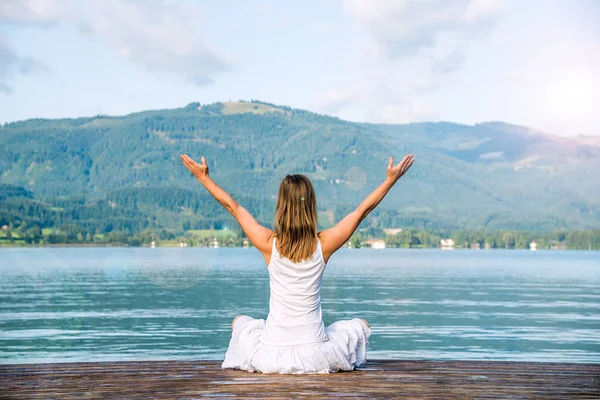 Mulher meditando no lago — Fotografia de Stock