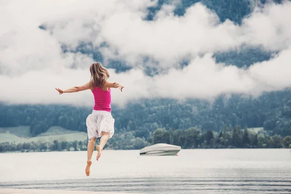 Mulher pulando no lago — Fotografia de Stock