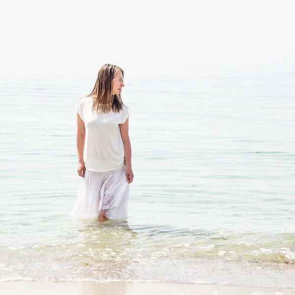 Mulher de pé na praia — Fotografia de Stock