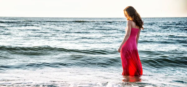 Kobieta stojąc na brzegu morza — Zdjęcie stockowe