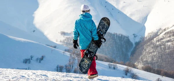 Snowboarderin steht mit Snowboard, — Stockfoto