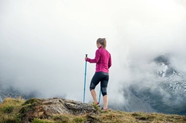 Dağlarda yürüyüş yapan genç bir kadın.