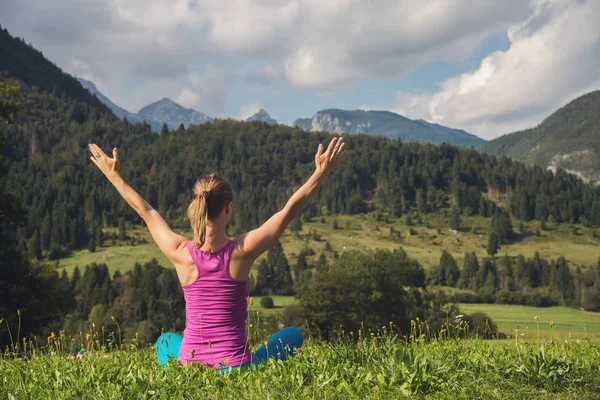 Ung kvinna meditera på toppen av berget — Stockfoto