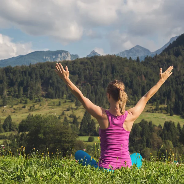 Genç kadın meditasyon dağın zirvesinde — Stok fotoğraf