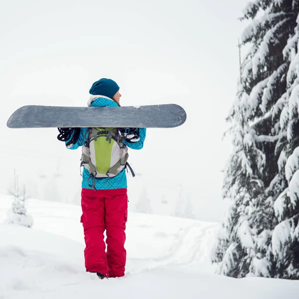 Snowboardåkare flicka som står med snowboard, — Stockfoto