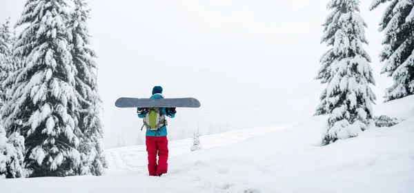 Snowboarderin steht mit Snowboard, — Stockfoto