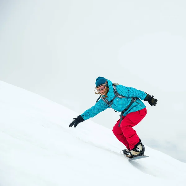 Jovem mulher no snowboard — Fotografia de Stock