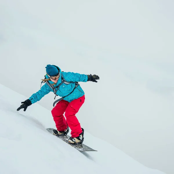 Νεαρή γυναίκα στο snowboard — Φωτογραφία Αρχείου