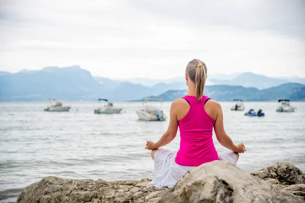 Frau meditiert am See — Stockfoto