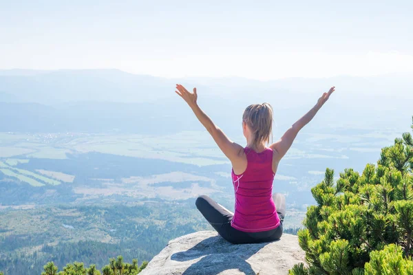 Jonge vrouw mediteren op de top van de berg — Stockfoto