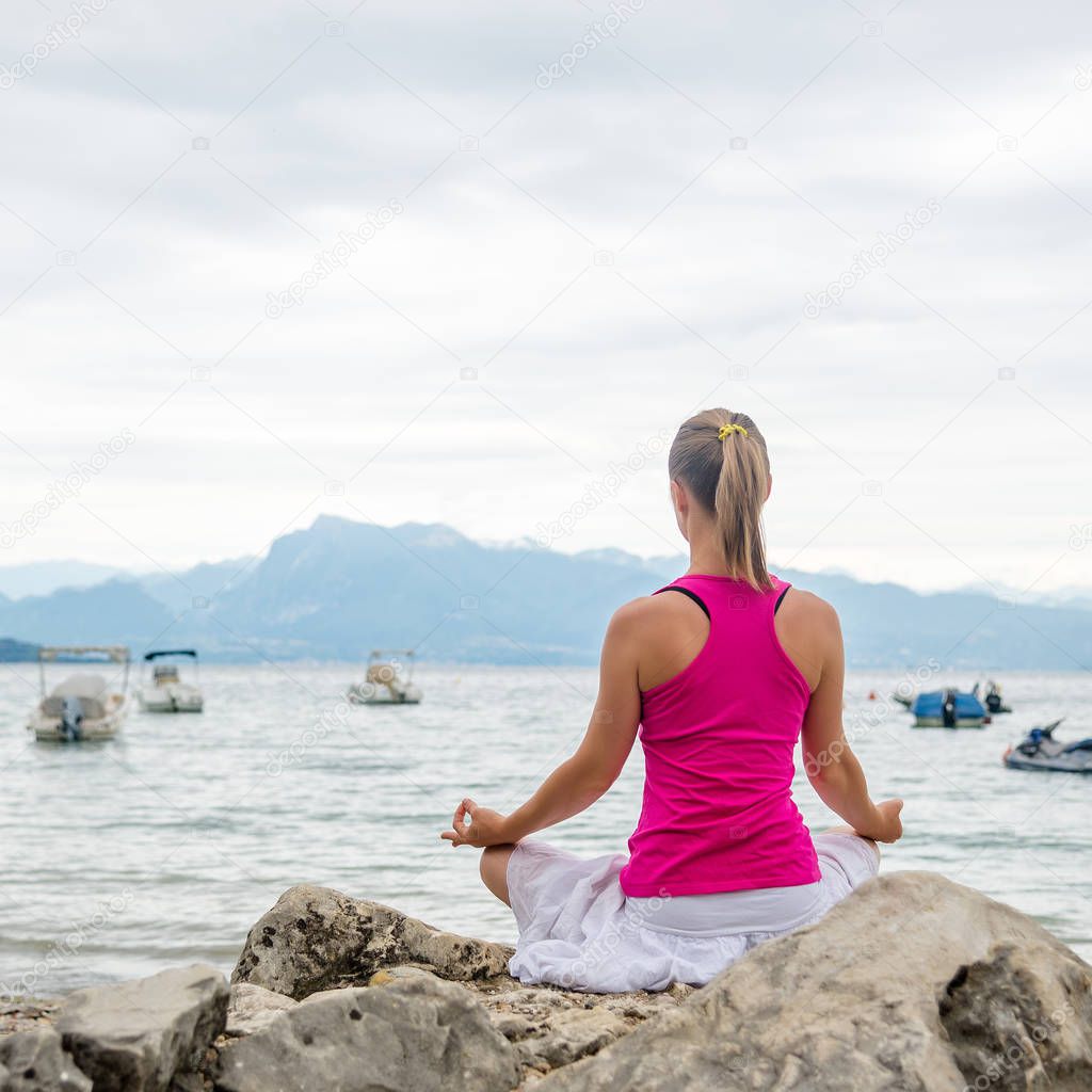 Woman meditating at the lake