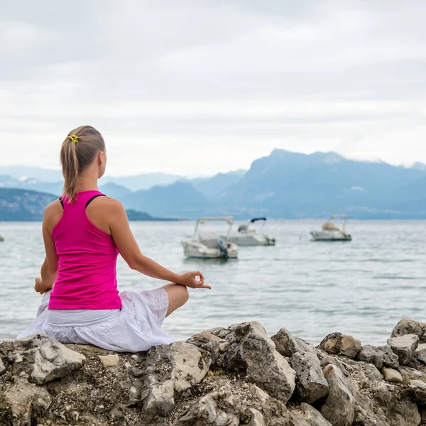Mujer meditando en el lago — Foto de Stock