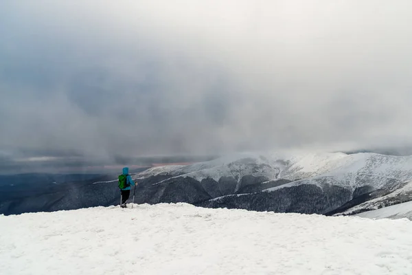 Jovem mulher caminhando nas montanhas de neve — Fotografia de Stock