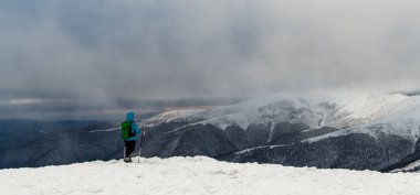 Young woman hiking in the snow mountains