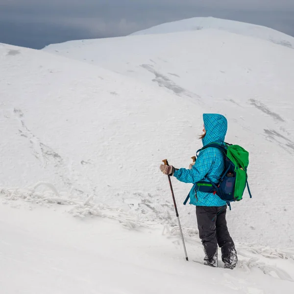 Young woman hiking in the snow mountains — Stok fotoğraf