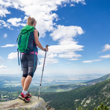 Dağlarda yürüyüş yapan genç bir kadın.